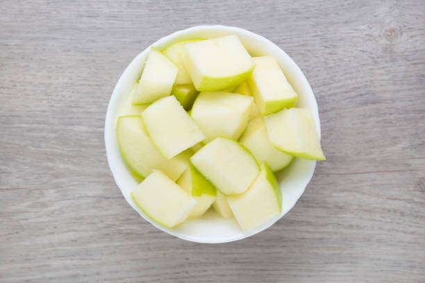Sliced pieces of granny smith apple in white bowl. Directly above view. photo is taken with dslr camera in studio green apple slice overhead stock pictures, royalty-free photos & images