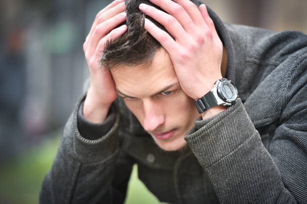 istock young sad man thinking while sitting on a bench in autumn 898403562