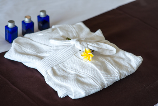 close-up shot of bathroom amenities with bathrobe on bed in hotel room