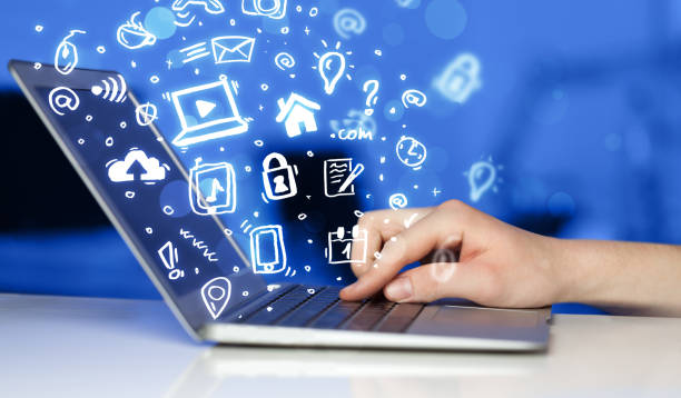 istock Hand writing on notebook computer with media icons and symbols 898416026