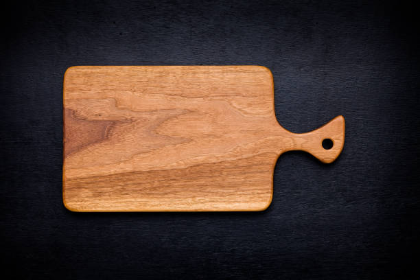 istock Walnut handmade wood cutting board on black wooden board 898419092