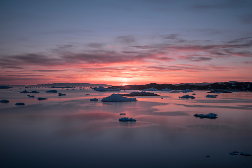 Arctic Icebergs with sunset on Arctic Ocean in Greenland. Climate change
