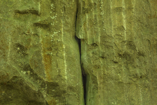 Photographed on a sunny day in the spring in the Ukrainian Carpathians. Cleft in rock. Beautiful relief and texture of stone. Stone background