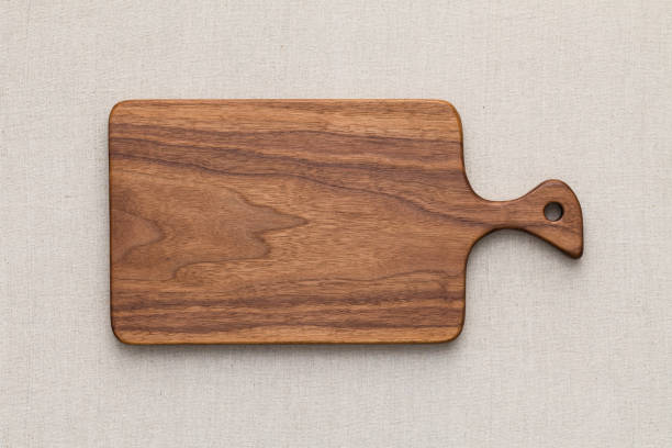 istock Walnut handmade wood cutting board on the linen 898428940