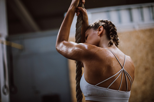 Athlete Woman Exercising Rope Climbing At Gym