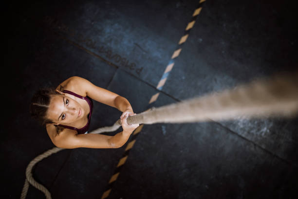 Moving Up Yung Woman Moving Up Rope clambering stock pictures, royalty-free photos & images