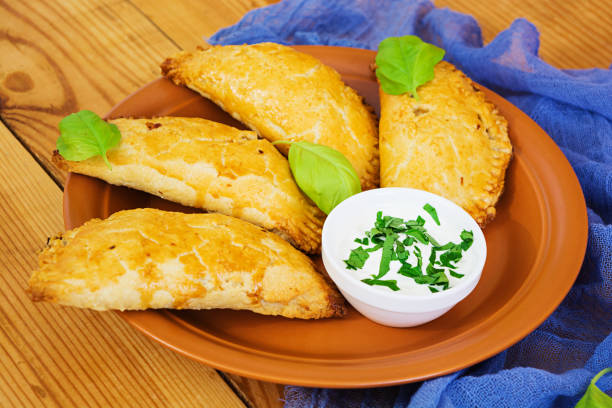 istock Baked empanadas on wooden background 898429850