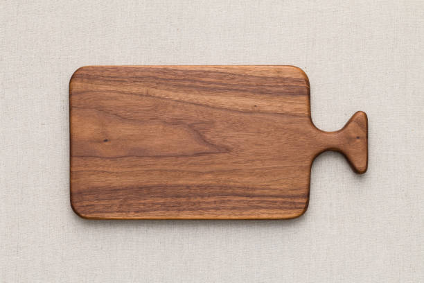 istock Walnut handmade wood cutting board on the linen 898430000