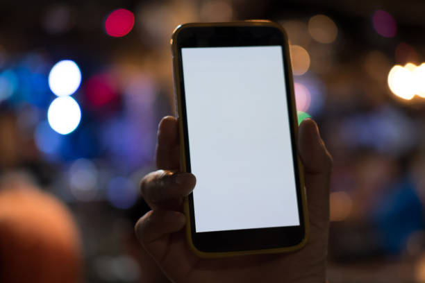 hand holding smartphone in pub. mobile phone with blank white screen in vertical position in cafe