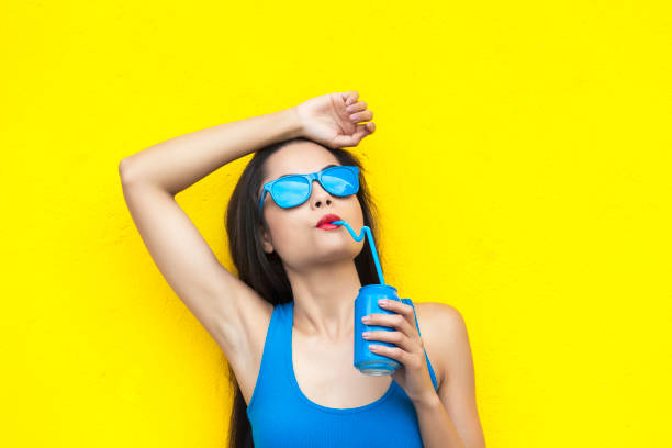 istock Woman with blue sunglasses drinking from blue can 898430056