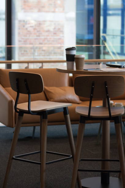 istock Close up image of unoccupied seats in an office environment with laptop computer and coffee cups with no people. 898431588