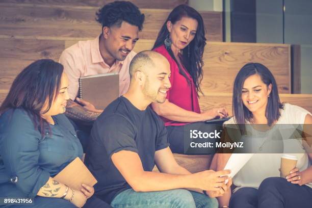 Five Business People Having A Meeting On The Stairs In The Work Environment Stock Photo - Download Image Now