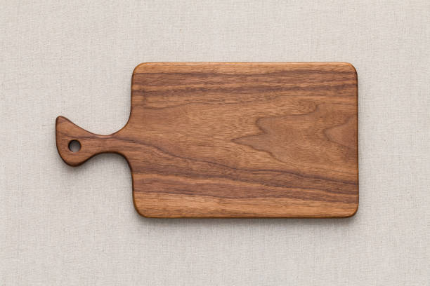 istock Walnut handmade wood cutting board on the linen 898435314