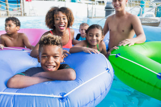 istock Mixed race boy with friends at water park on lazy river 898439382