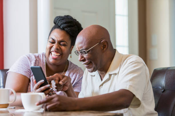 istock Senior man with adult daughter using smart phone 898439634