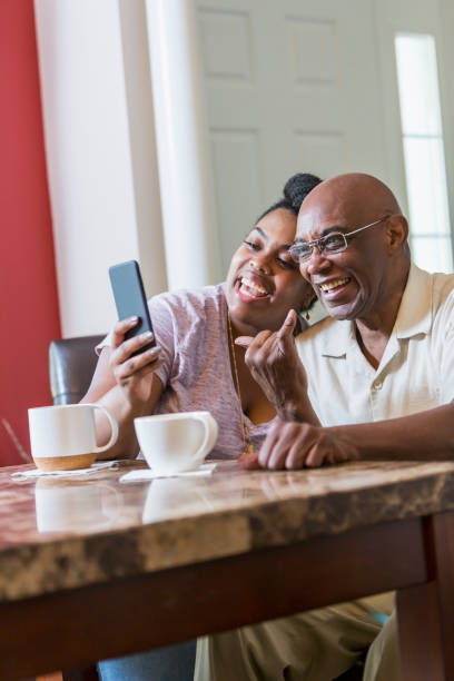 istock Senior man with adult daughter using smart phone 898439670