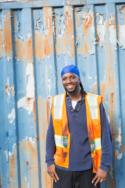 istock Worker standing in front of old semi-truck trailer 898440248