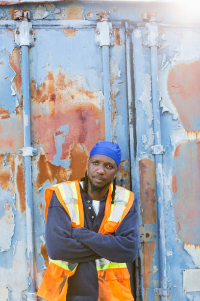 istock Worker standing in front of old semi-truck trailer 898440372