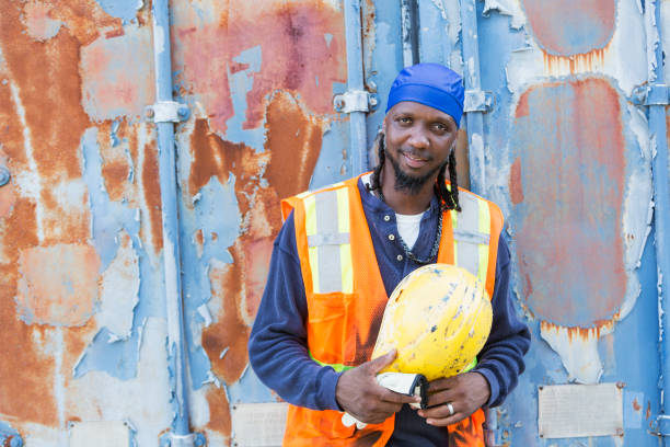 istock Worker standing in front of old semi-truck trailer 898440376