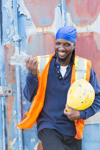 istock Worker standing in front of old semi-truck trailer 898440400