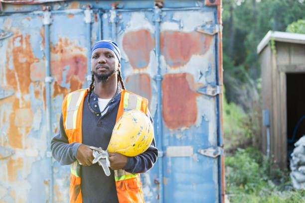 istock Worker standing in front of old semi-truck trailer 898440414