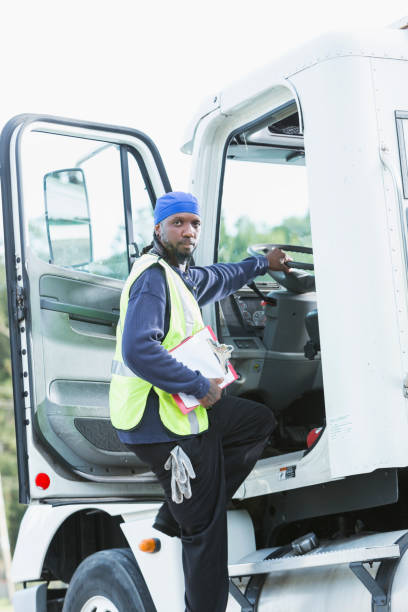 istock Semi-truck driver climbing into cab 898440470