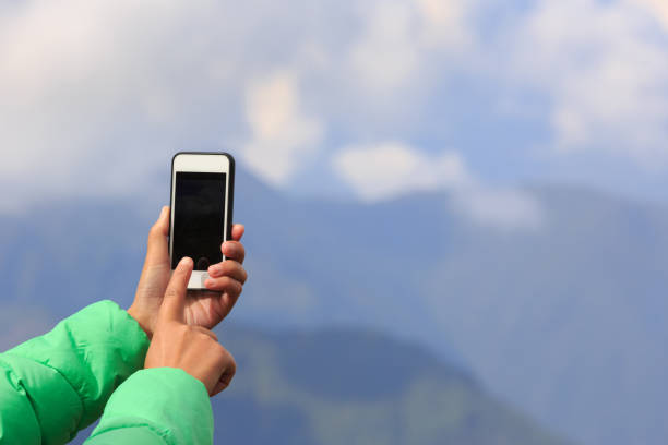 istock Successful woman backpacker taking selfie on mountain peak 898440968