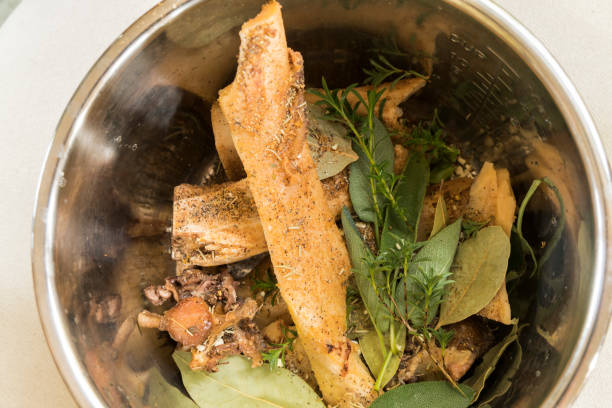 istock Pressure cooker pot filled with beef bones, sage, thyme, and seasoning to make bone broth 898447156