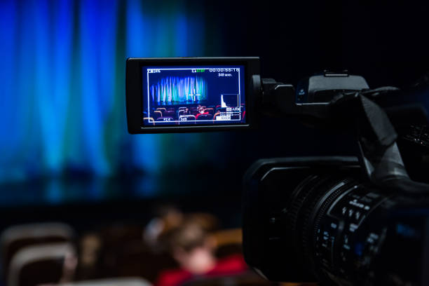 istock Video camera in the auditorium. Spectators gather in the hall before the performance. LCD display on the camera 898447338