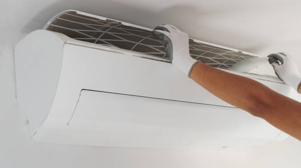istock Hand of technician cleaning air conditioner in house 898450832