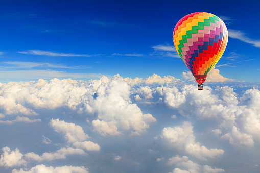 Hot air balloon over the white cloud on blue sky
