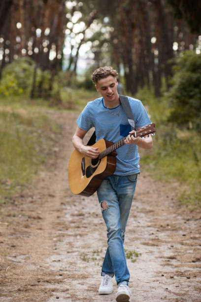 istock Walking guitarist playing forest hiking concept. 898452492