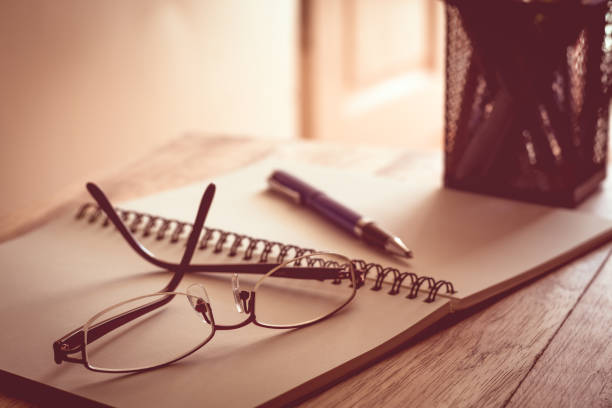 istock Glasses, notebook and pen on wooden table. 898453806