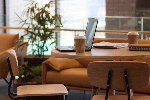 istock Close up image of unoccupied seats in an office environment with laptop computer and coffee cups with no people. 898453870