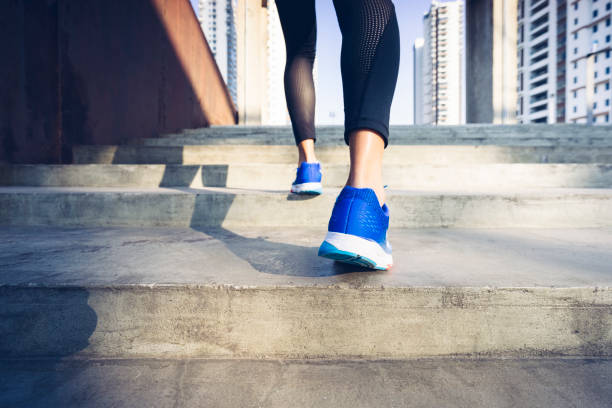 istock woman running up stairs,low section 898454060