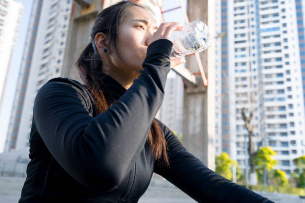 istock asian female athlete on steps and drinking 898455984