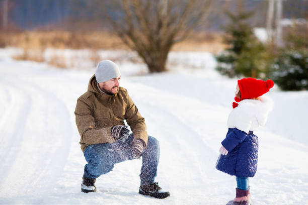 istock Father and daughter at snowy park. 898457918