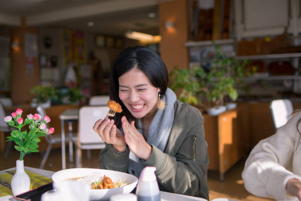 Happy woman eating fried chicken for lunch