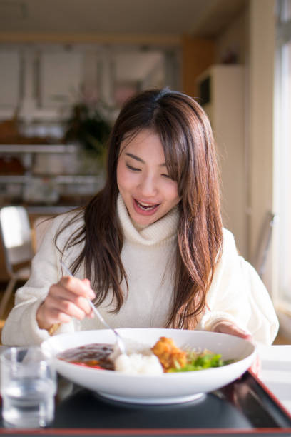 istock Young woman eating curry for lunch 898458856