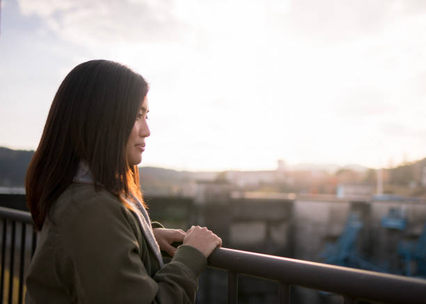 istock Young woman looking over scenery in sunset 898458942