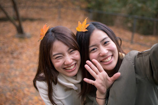 istock Happy sisters taking selfie picture with fallen leaves on head 898459446