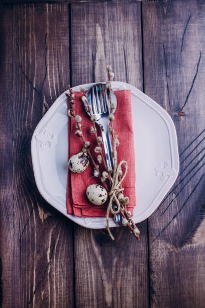 istock Easter table setting. White or beige plate, cutlery, eggs and pussy willow on wooden background table. Top view and copy space. 898459812