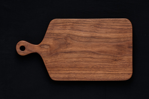 Tablero de nogal corte madera hecha a mano en algodón negro photo