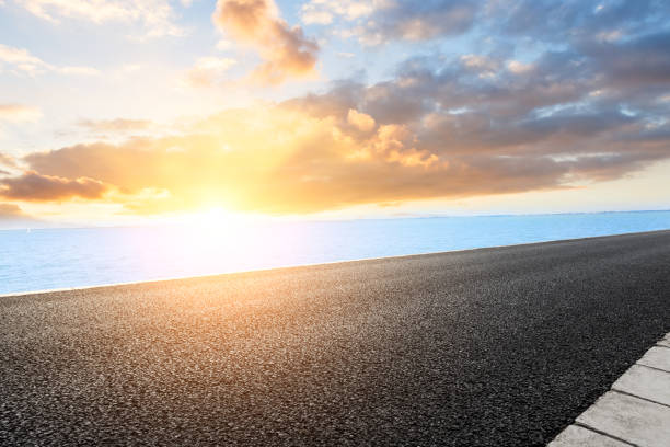 istock asphalt road and lake nature landscape at sunset 898463870