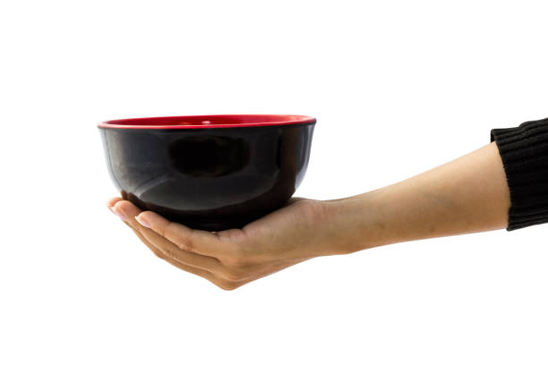 istock Female hand holding empty black bowl isolated on white background with clipping path for graphics, cut out, editing. A bowl is a round, container used to serve hot and cold food. 898467808