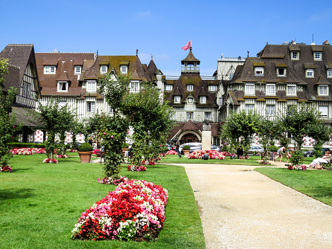 Deauville, Normandy, France - 7 August 2014:   Seaside 5-star Hôtel Normandy Barrière and its gardens. With its race course, harbour, international film festival, marinas, conference centre, villas, Grand Casino and sumptuous hotels, Deauville is regarded as the \
