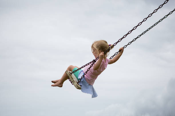 istock Little girl swinging 898470442