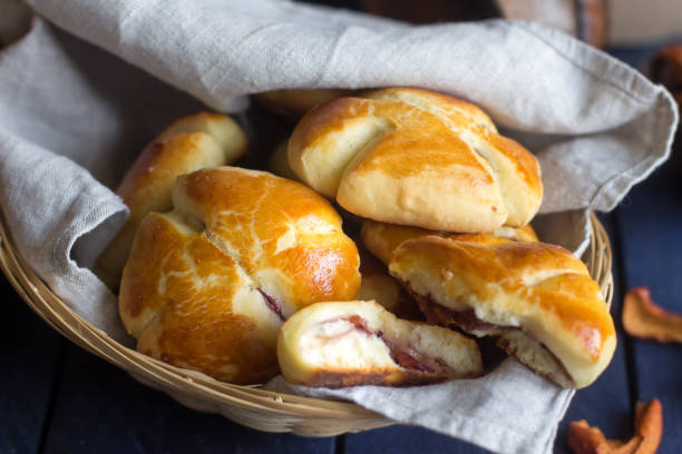istock Freshly baked bread with a dried fruits on rustic table. Buns in a basket 898470632