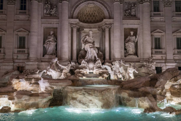 The Trevi Fountain in the Trevi district in Rome in late evening. It's one of the most famous baroque fountains in the world. It was designed by Italian architect Nicola Salvi and completed by Pietro Bracci