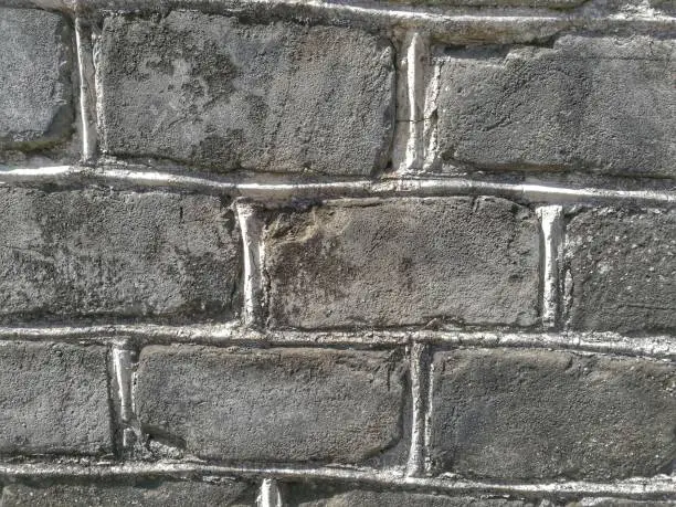 Untidy masonry; use uneven sizes of gray concrete bricks. Use for background, backdrop, texture, or image montage in concept of construction work done by villagers (not skilled workers).